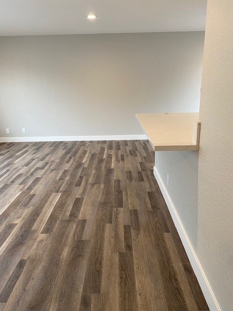 A room with a wooden floor and a white wall.